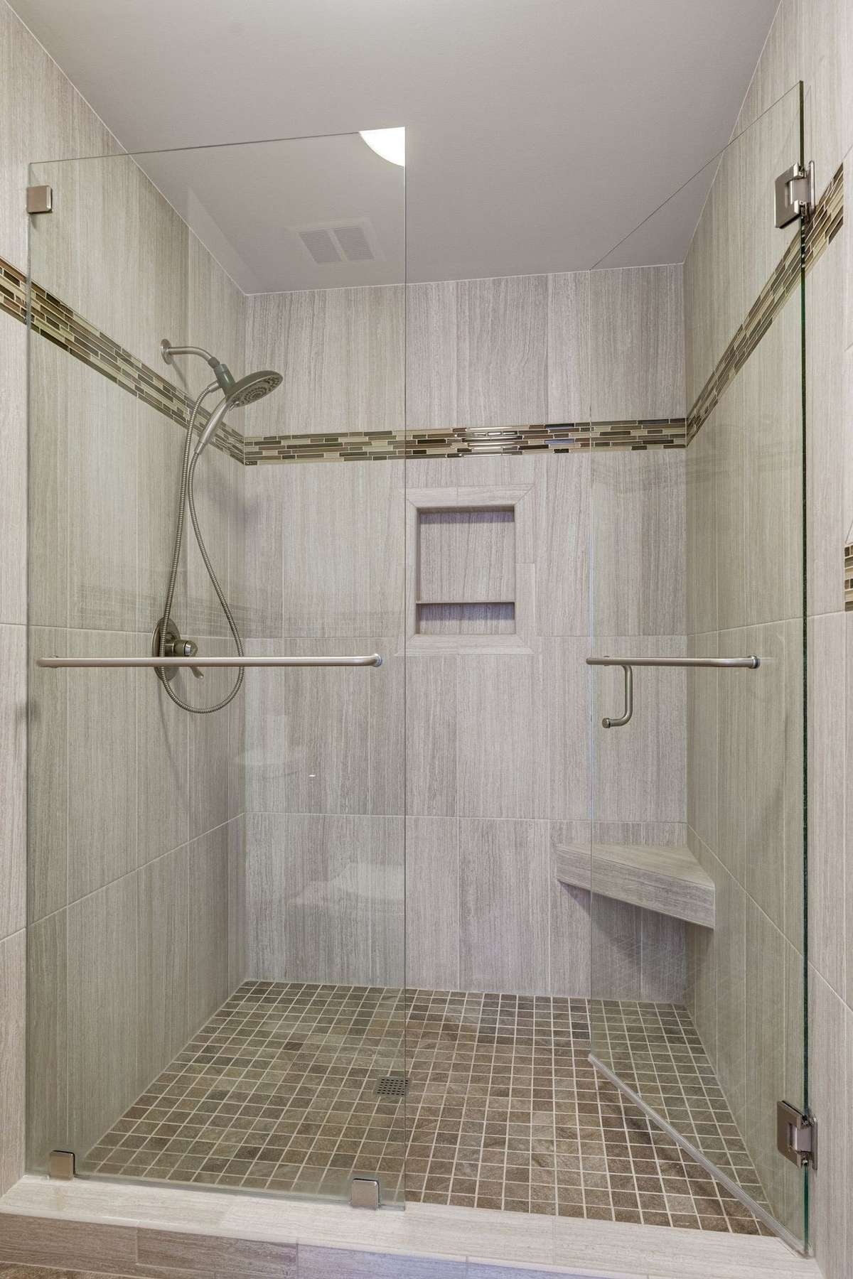 Oversized walk in modern shower with custom tile and a frameless glass door