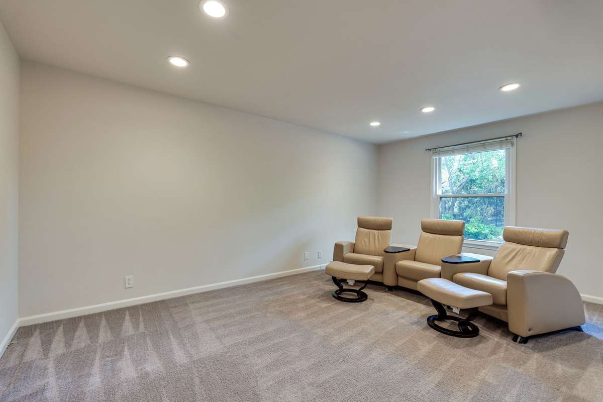 Spacious den with sleek puck lighting and a lush carpeted floor