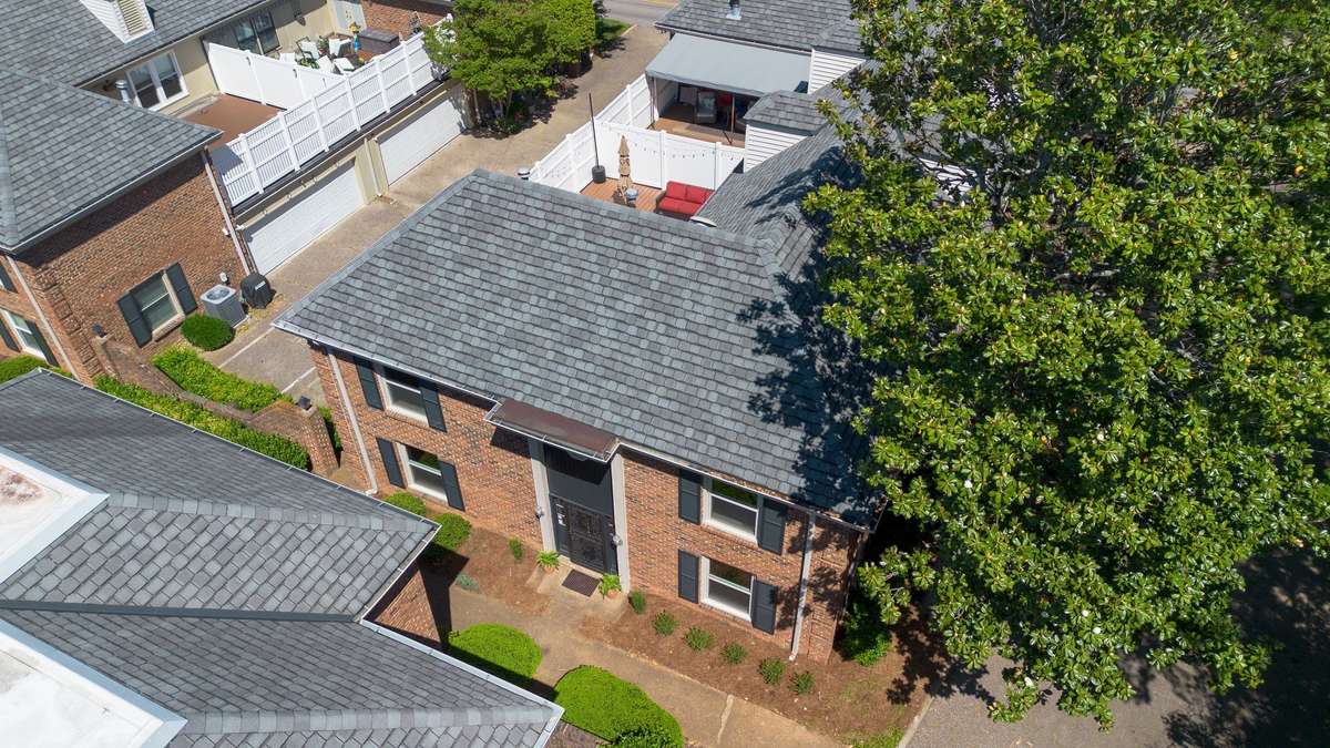 Areal shot showing the townhome, the upper floor private deck and the community sidewalk