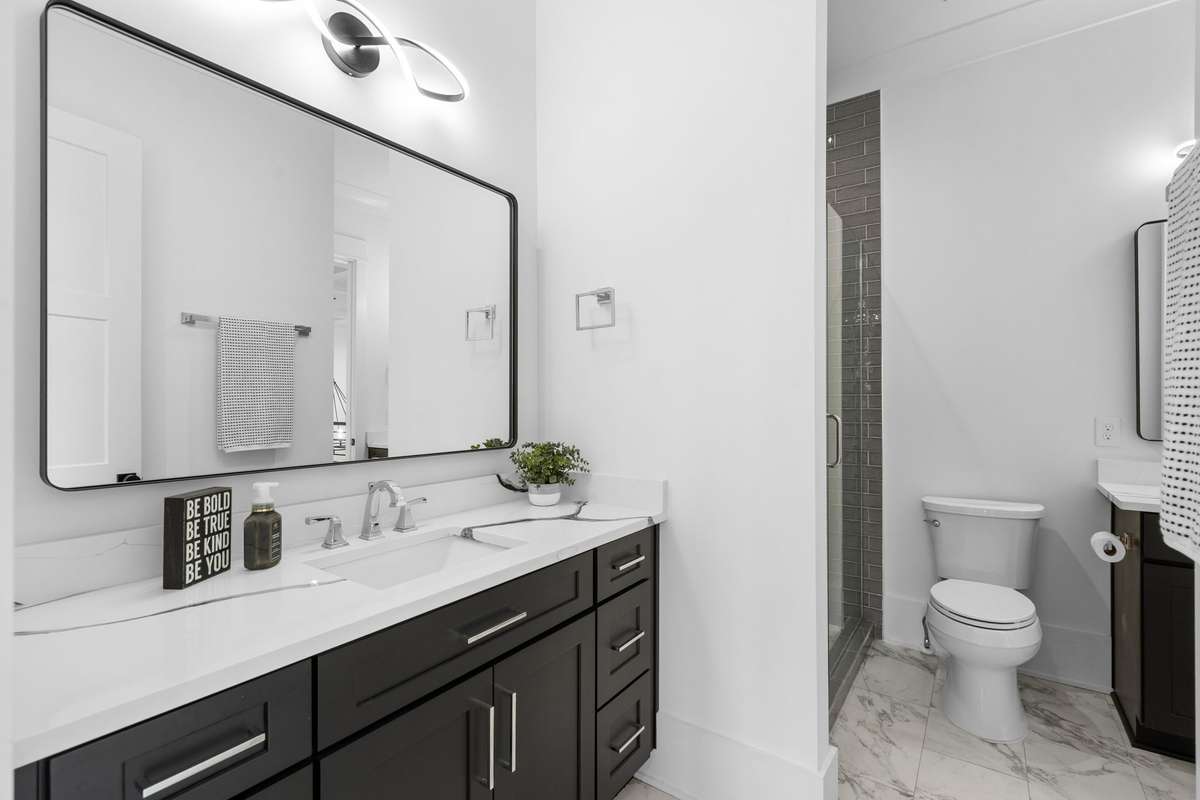 Sleek quartz countertops, modern cabinetry, and clean, contemporary finishes beautifully compliment Bedroom #4's ensuite bathroom.