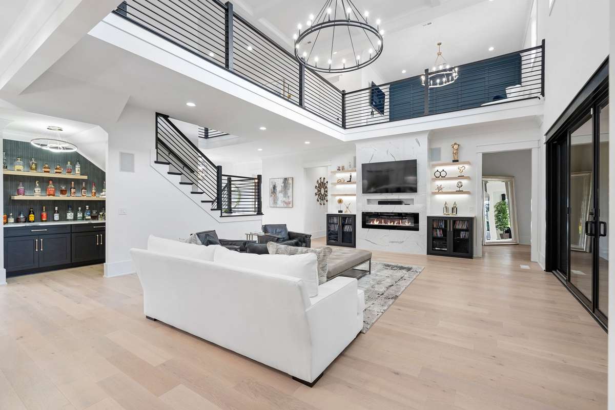 Two-story living space featuring modern railing loft, wide open floor plan, and seamless flow.