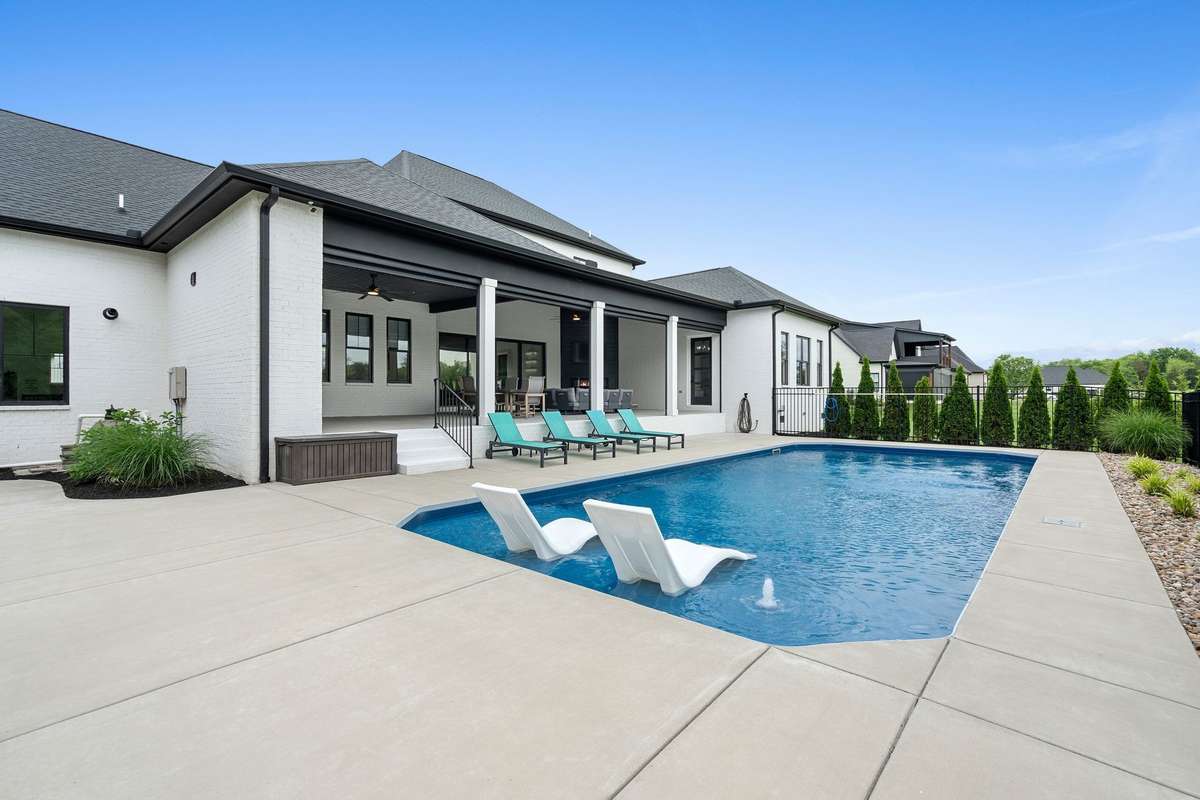 Resort-style saltwater pool with tanning ledge, complemented by a spacious covered patio for effortless outdoor living.
