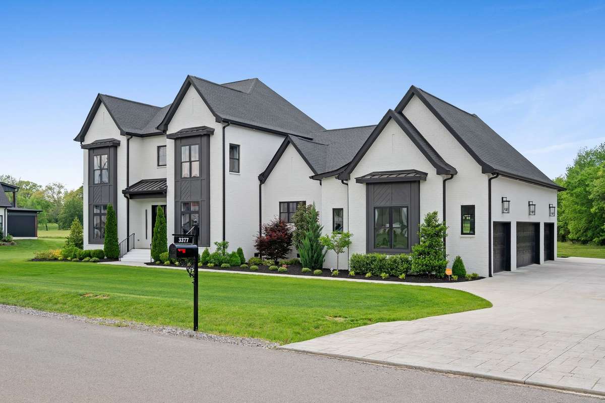 Expansive driveway + rare side-entry 4-car garage with EV hookup and abundant concrete parking pad.