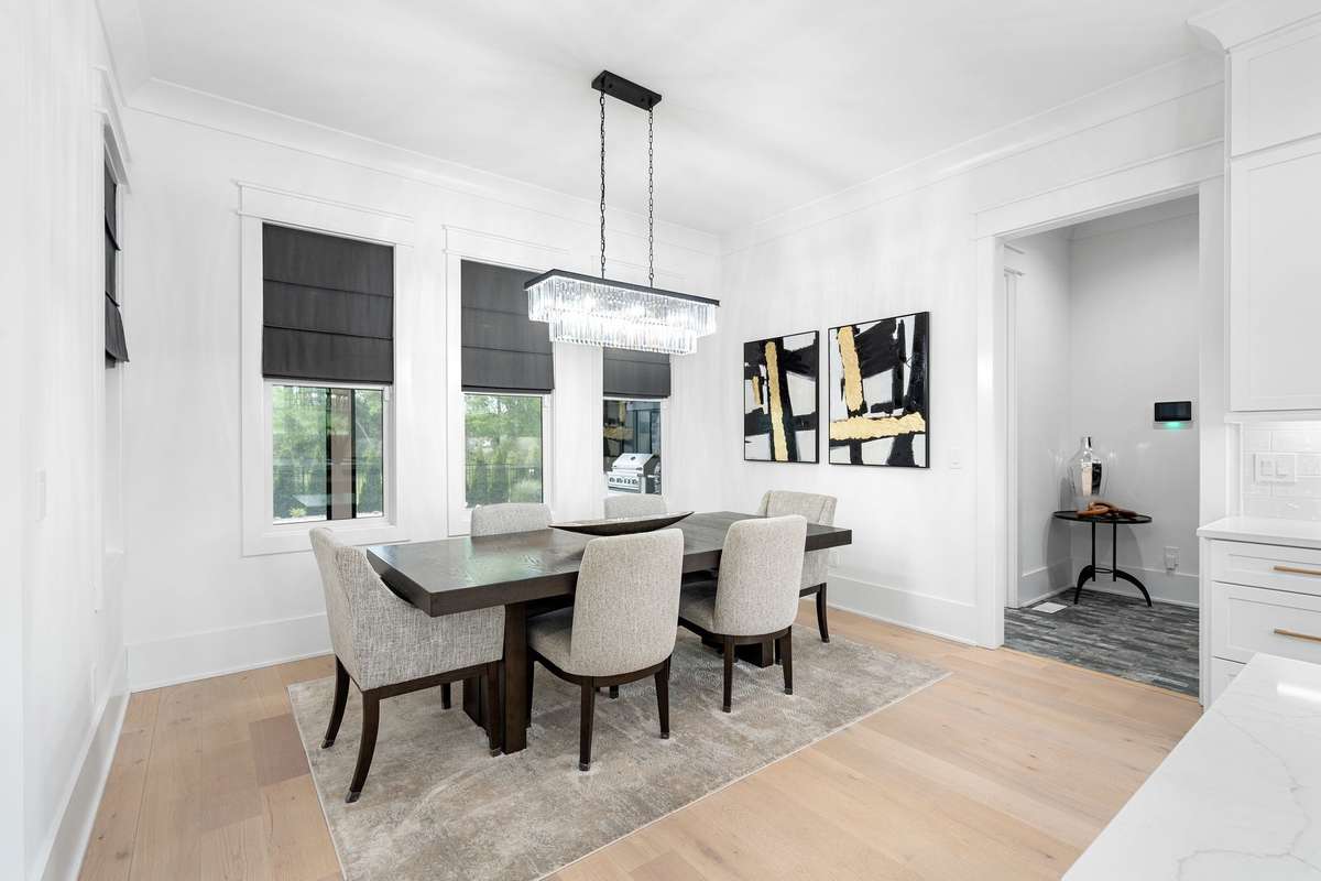 Elegant dining space with designer lighting and views of the private backyard.