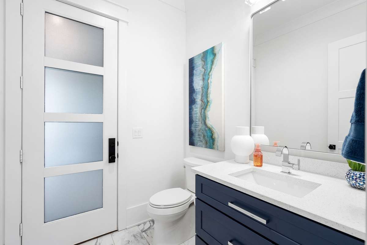 Stylish main-level powder bath with modern finishes and sleek design is perfectly positioned as it leads to the outdoor living area and inground pool.