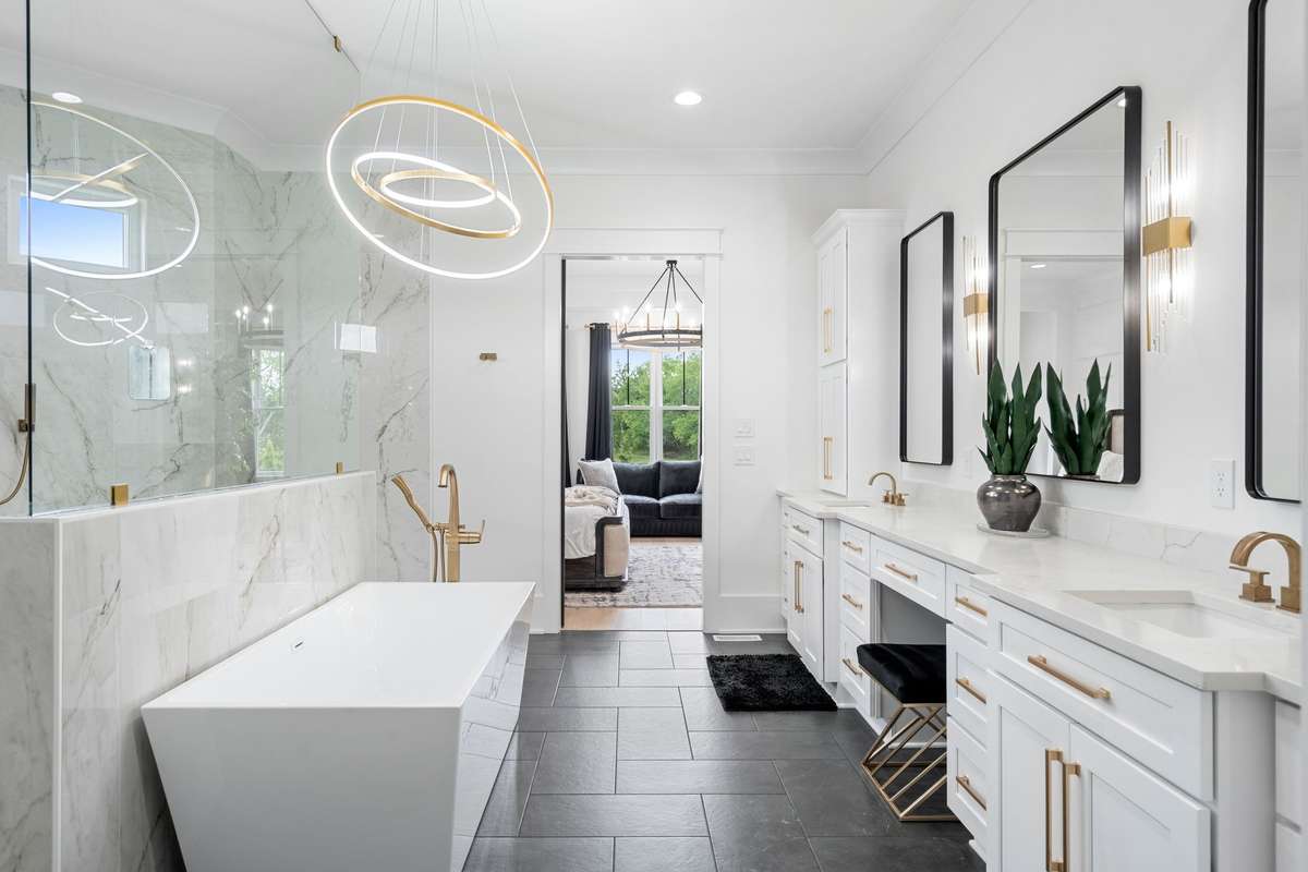 Freestanding soaking tub and oversized walk-in shower create a true luxury experience.