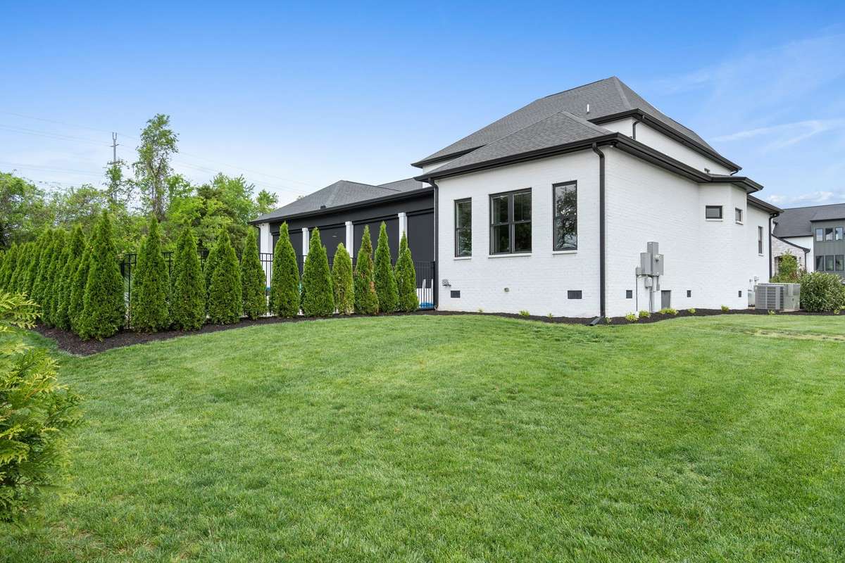Beautifully maintained grounds with lush lawn, curated landscaping, and clean contemporary exterior lines.