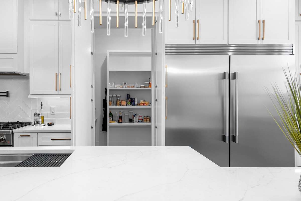 Seamless kitchen design with concealed pantry access and high-end appliance integration.