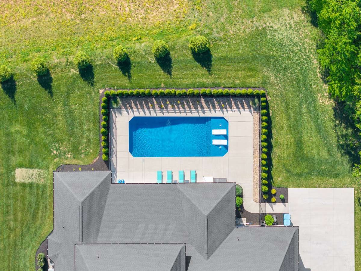 Direct overhead of the resort-style pool and patio, surrounded by privacy landscaping for a true retreat feel.
