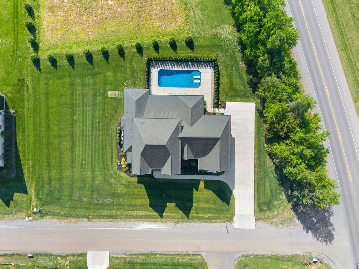 Overhead perspective highlighting the home’s footprint, driveway, and spacious yard.