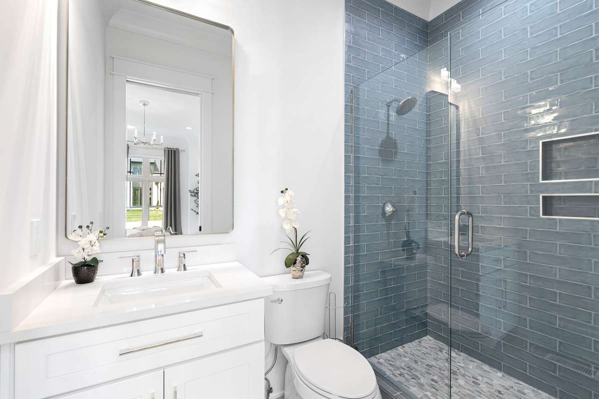 This beautifully appointed bath with custom tile shower and modern fixtures serves as the ensuite bath for downstairs Bedroom #2.