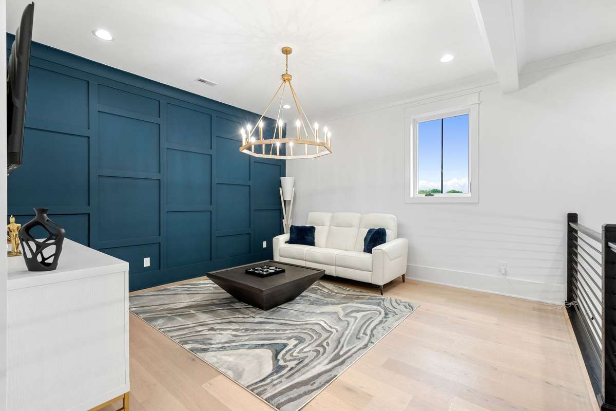 Stylish loft featuring custom accent wall, designer lighting, and comfortable gathering space.