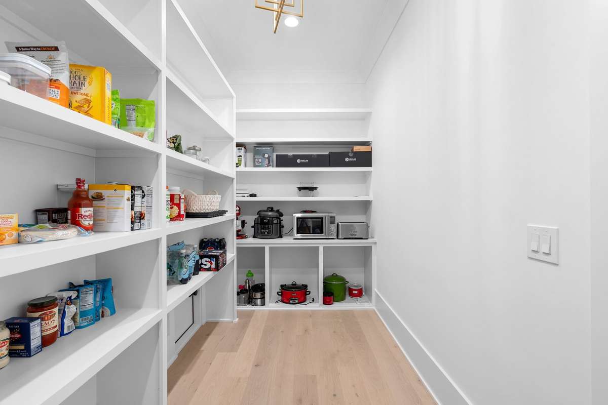 Bright and spacious pantry featuring extensive built-ins for ultimate functionality.