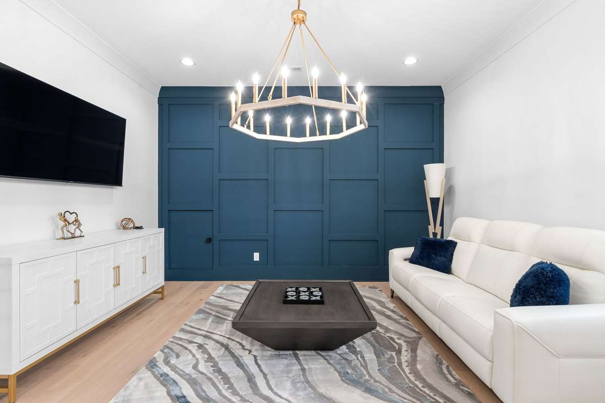 Expansive loft area features statement lighting; perfect for media, gaming, or entertaining.