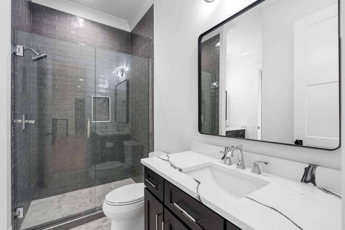Stylish tiled shower with glass enclosure and upscale fixtures for a polished look.