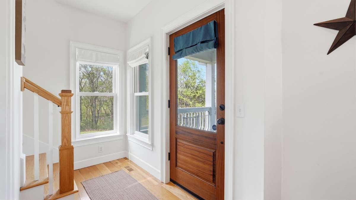 Entryway features ample natural light, stair access to 2nd floor, and a half bath for your guests.