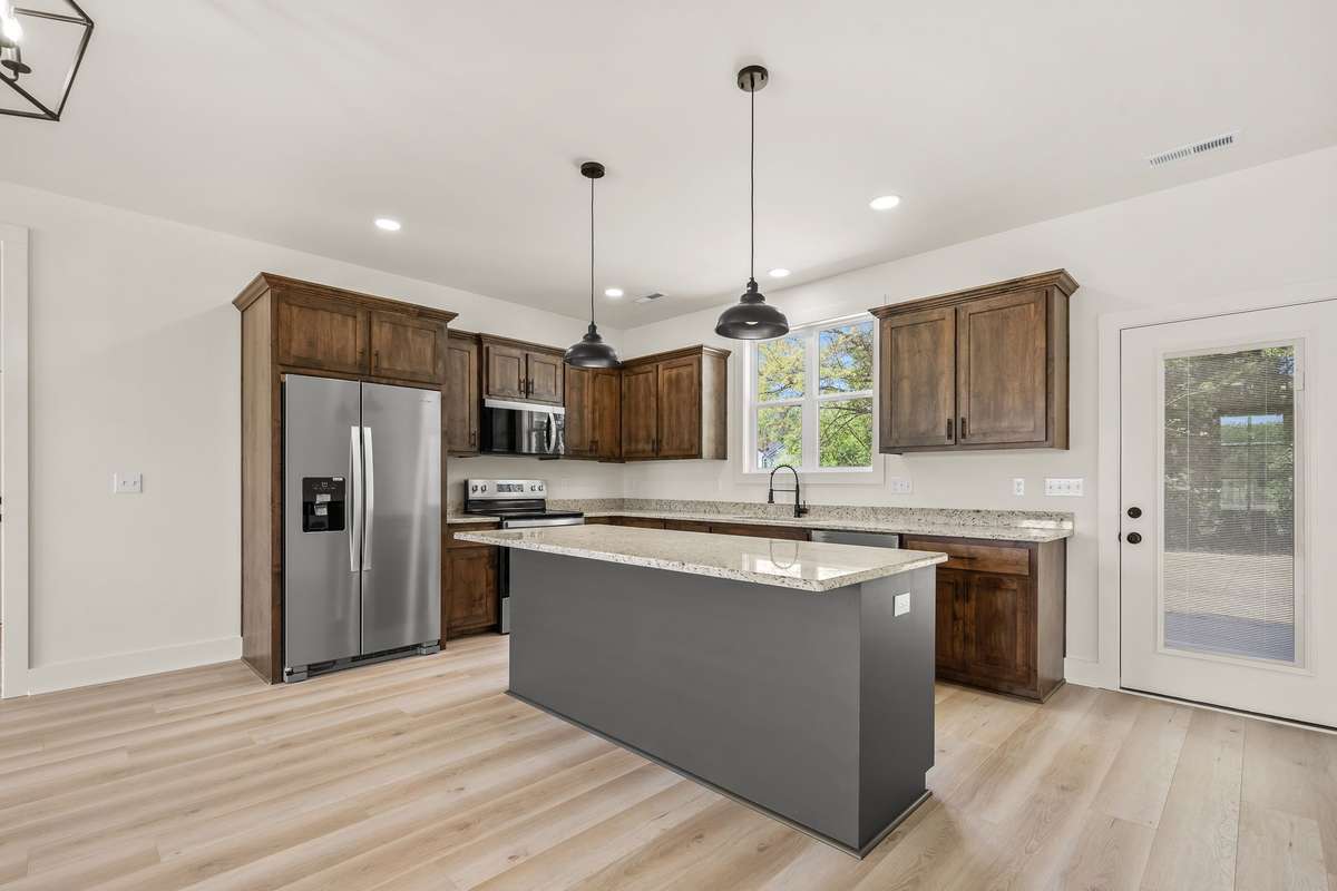 Kitchen offers custom cabinetry, tasteful lighting and stainless steel appliances!