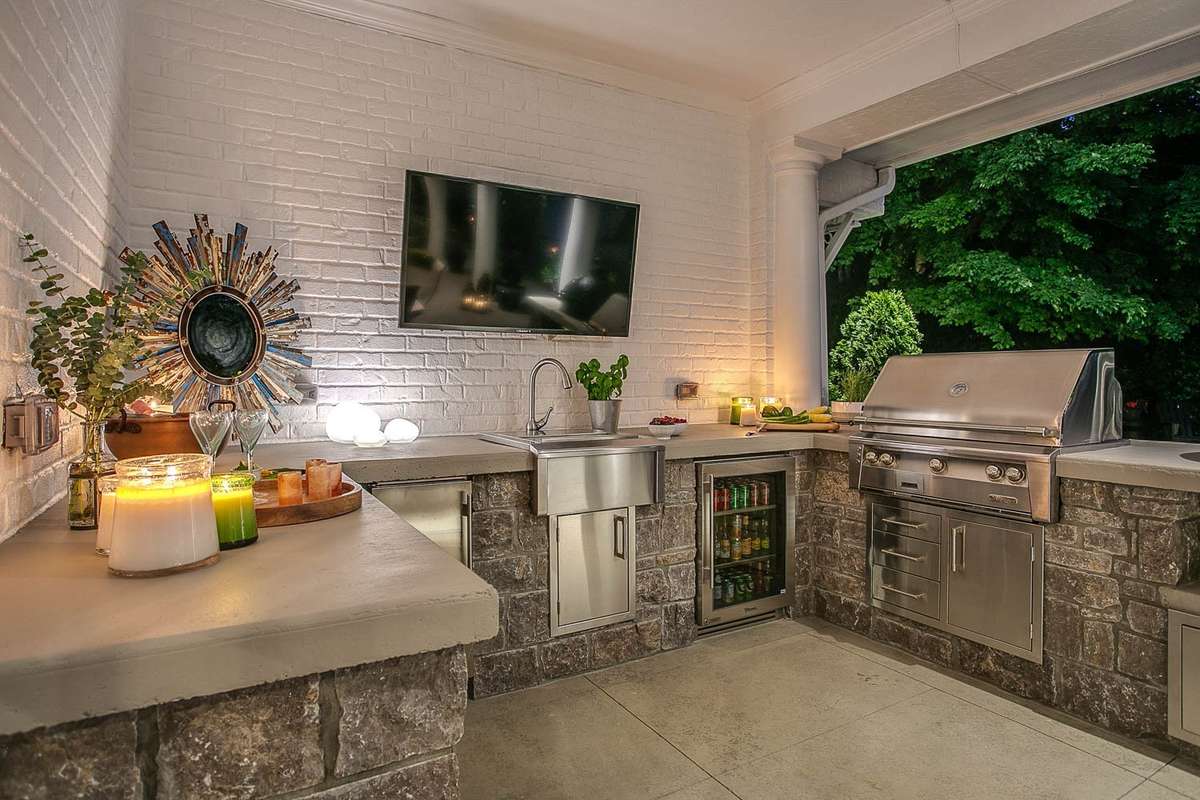 Now is the time to start enjoying your outdoor space...the summer kitchen was installed in 2020 and hosts a beverage fridge, ice maker, sink, grill and Green Egg...all of which remain with the home...