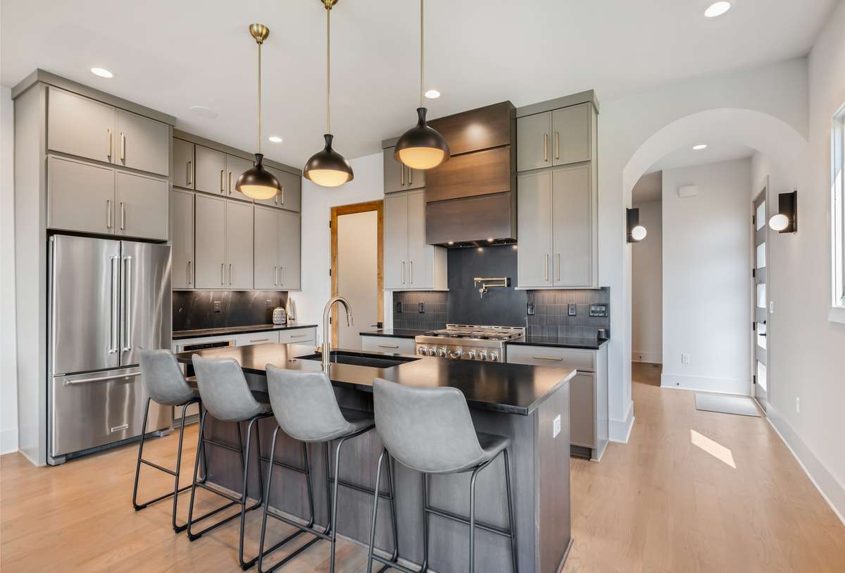The kitchen is a showstopper: luxury finishes, a large island, gas range, built-in microwave, trash pullout, and walk-in pantry, pot filler - every detail designed with intention.