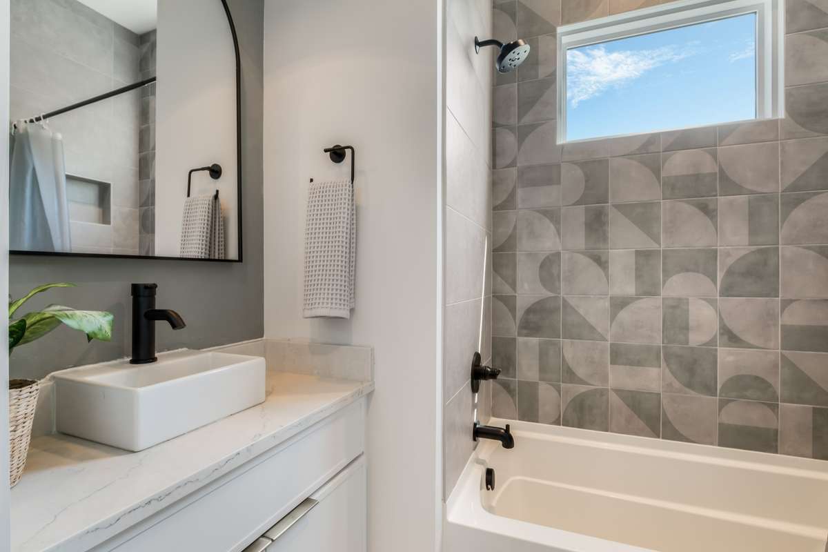 Sleek tile work, modern fixtures, and elevated finishes give each bathroom a custom, boutique feel.