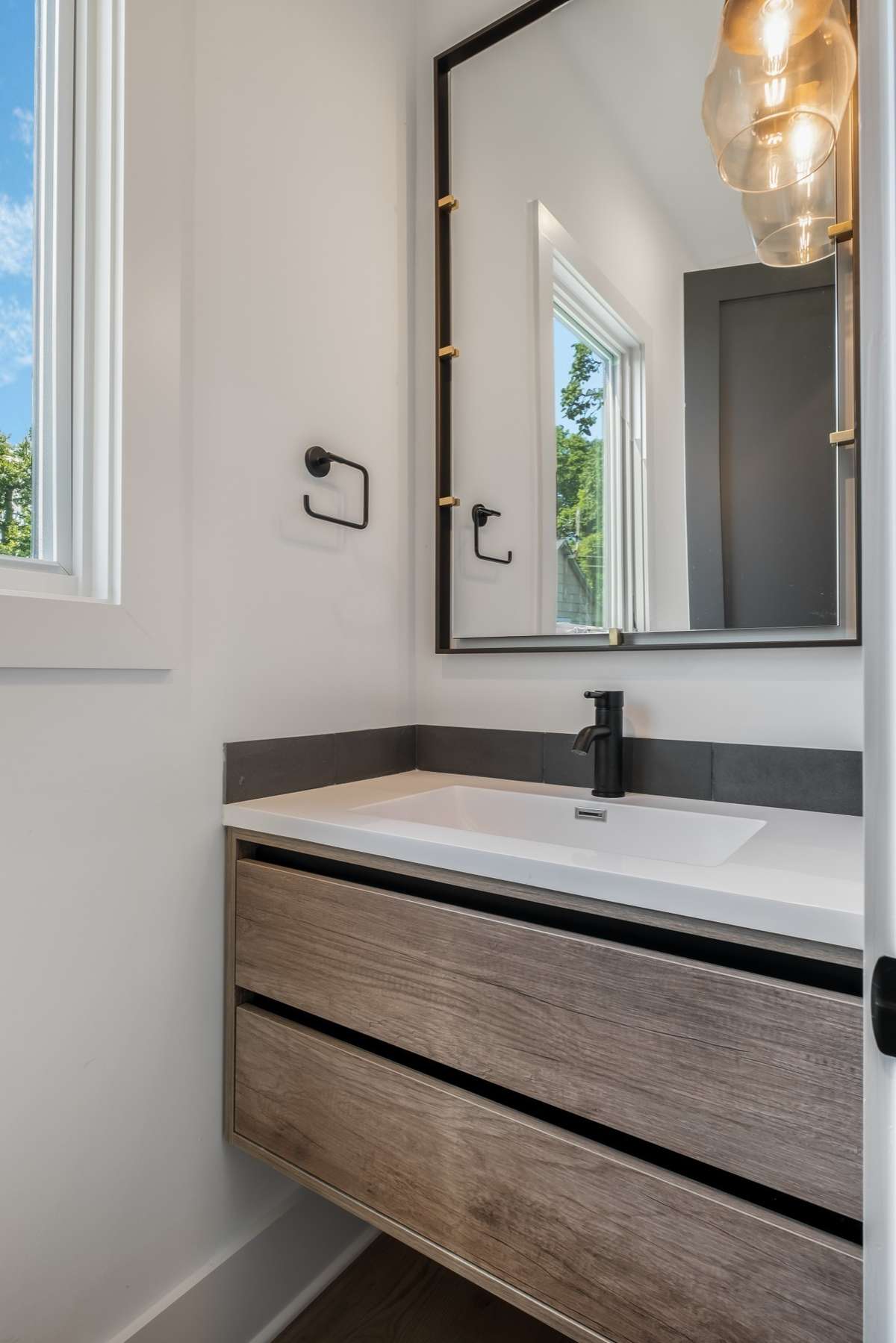 Chic and functional, the stylish half bath adds ease and elegance for guests.