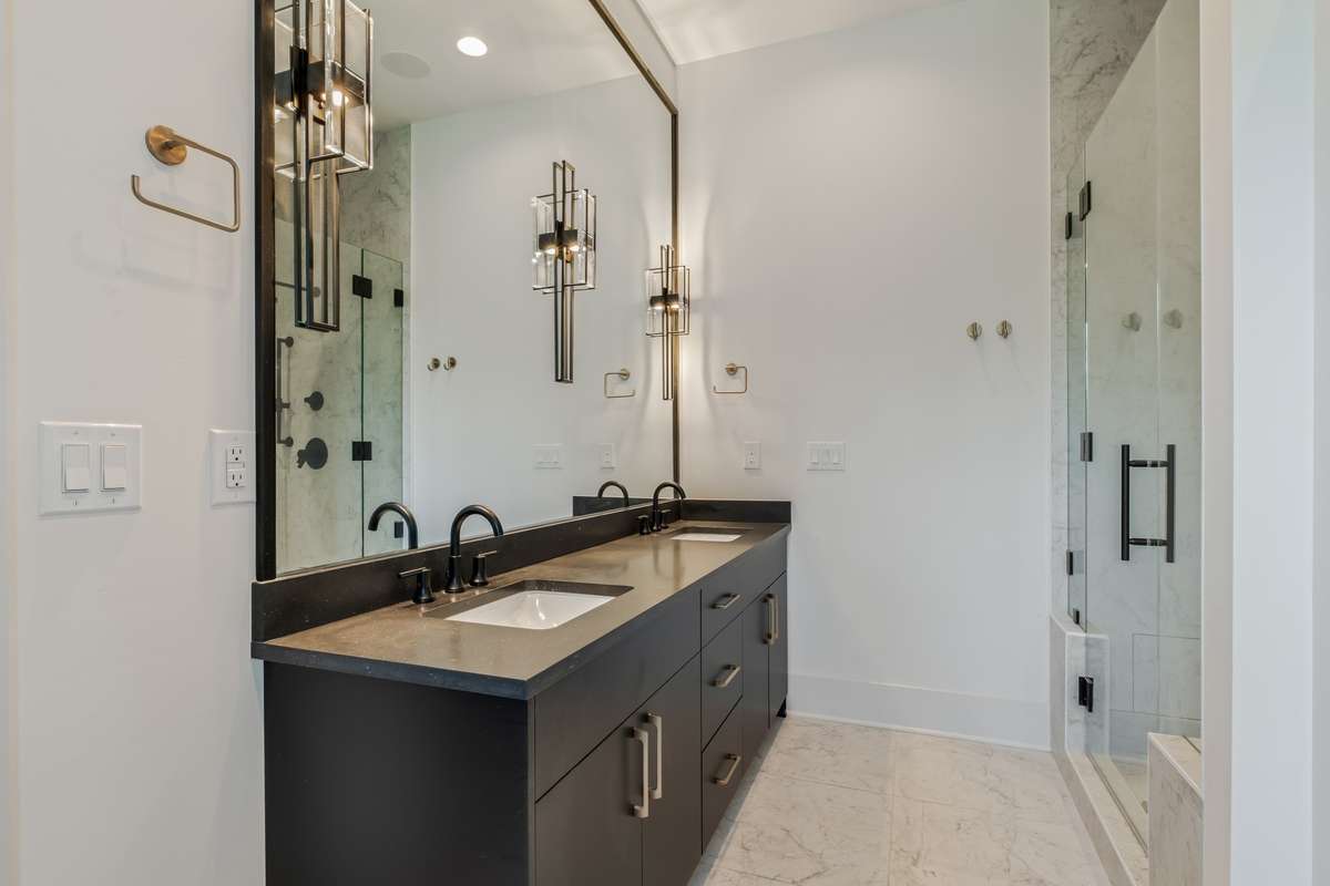 His and hers vanities with expansive mirrors and designer lighting elevate your morning routine with style and ease.