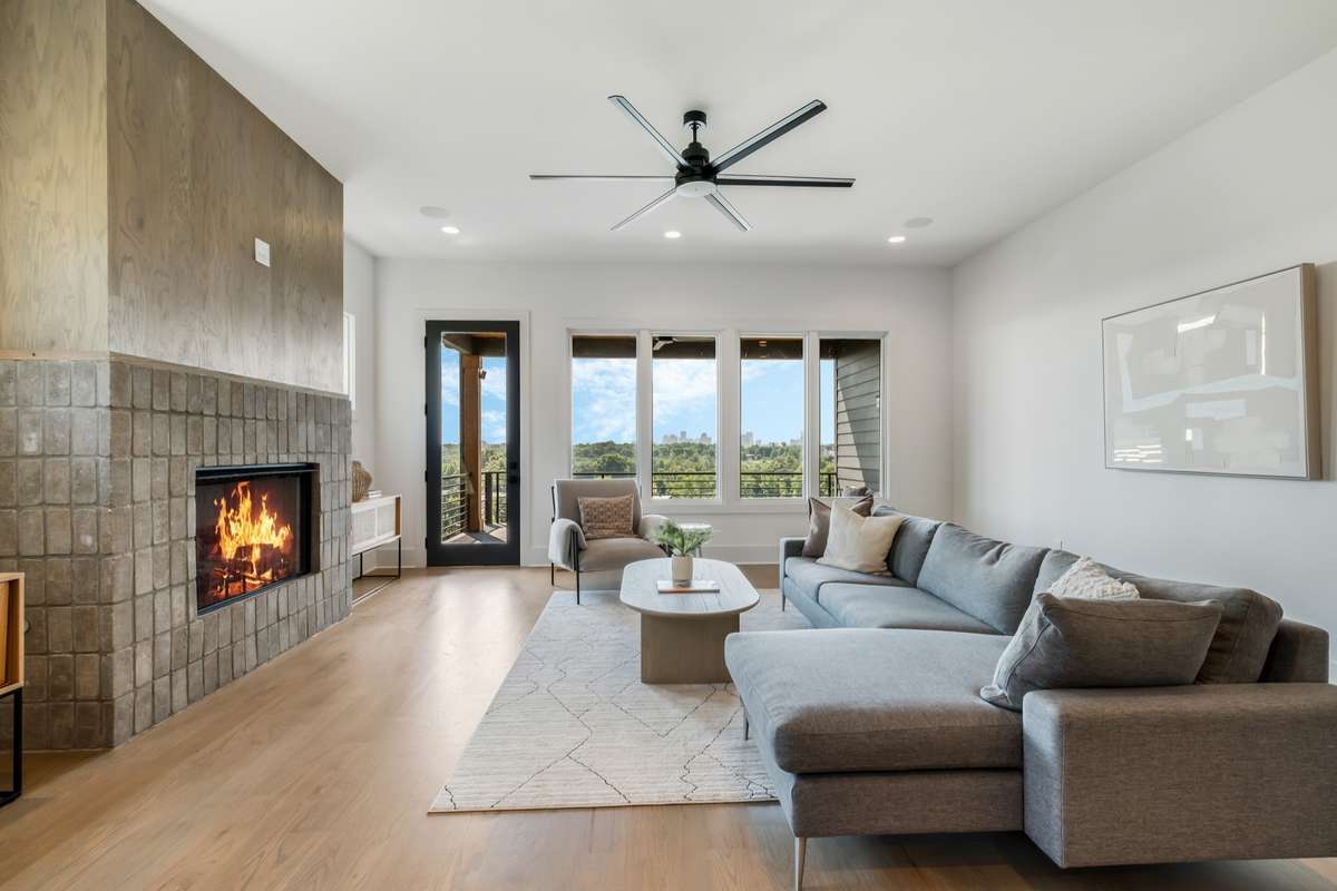 Cozy up by the fireplace while taking in ever-changing skyline views through walls of glass - luxury living with a view.