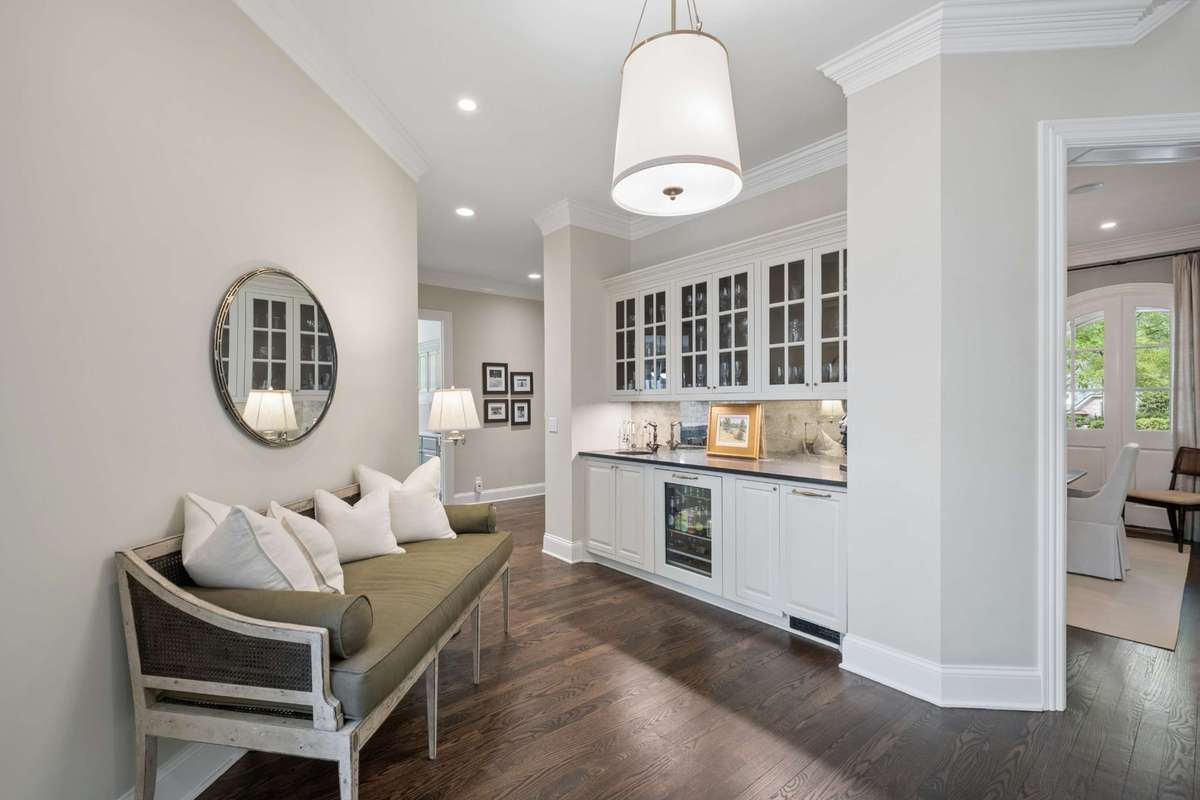Conveniently located between the Dining Room, Kitchen and Living Room, the handsome bar features custom glass front cabinets, honed granite countertops, an ice maker, and beverage refrigerator.