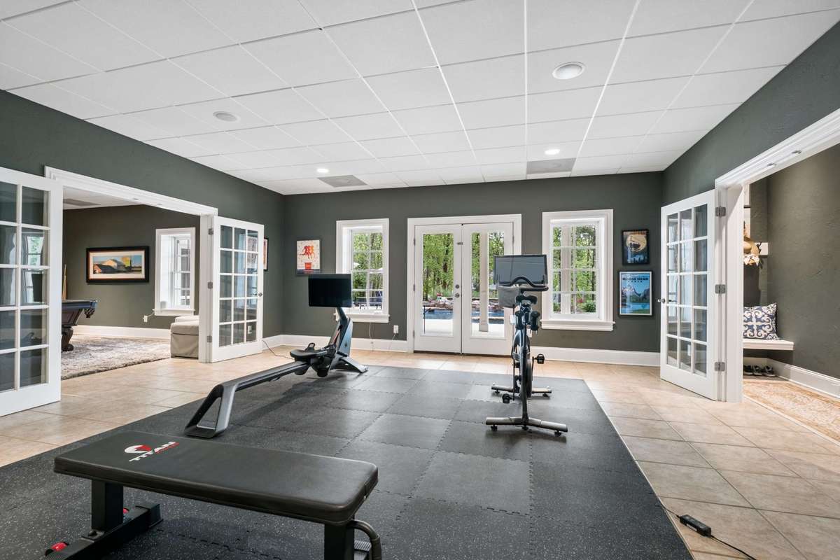 Plenty of amazing, flexible space in the basement. Currently being used as a Fitness Room, this room opens to the outdoor living space and pool area through French doors.