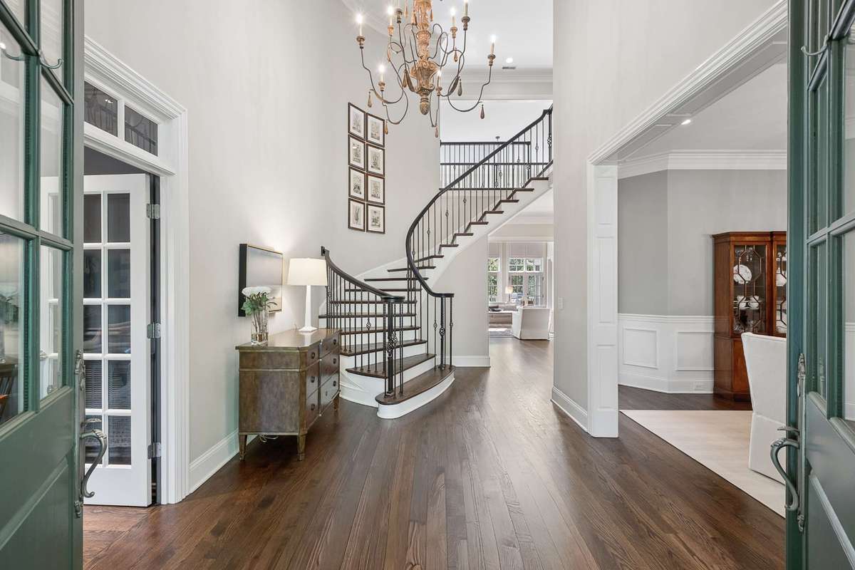 A stunning Entrance Hall with soaring ceilings welcomes you into the home and opens to the Dining Room and Office. Hardwood floors throughout and abundant natural light enhance the beautiful living spaces.