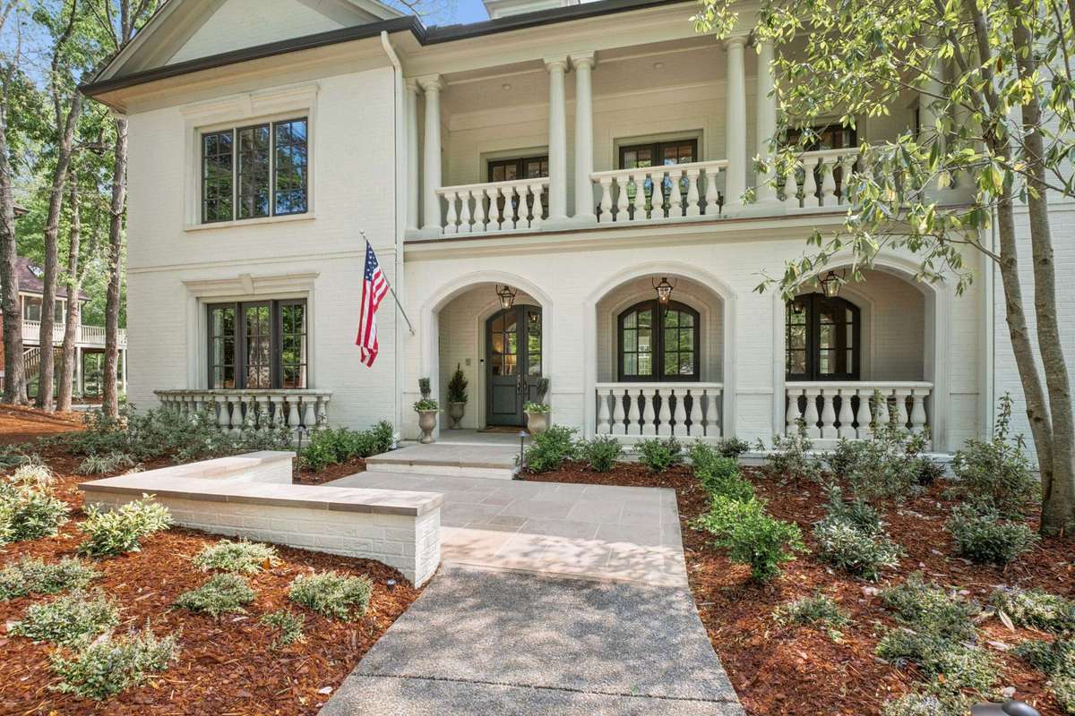 A beautiful limestone entrance and covered porch with Bevelo lanterns invite you into this thoughtfully renovated home.