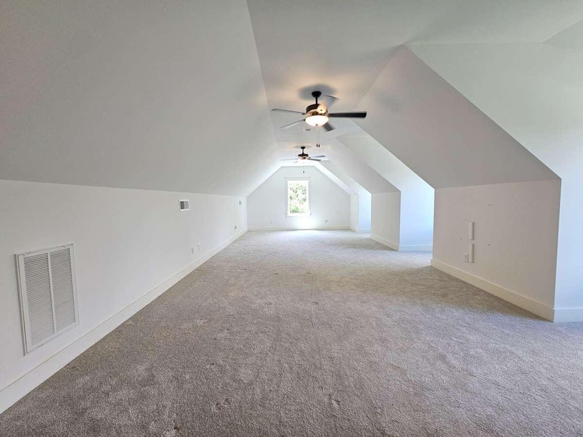 The bonus room is located above the main level garage with 2 ceiling fans and views of the front lawns and drive.