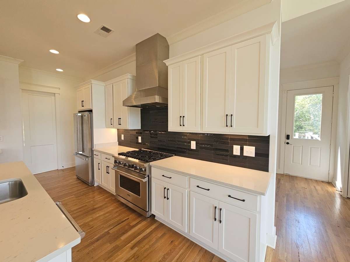 The kitchen has quartz countertops, tiled backsplash and a chef-grade gas stove and oven, french door refrigerator with pull out drawer freezer.