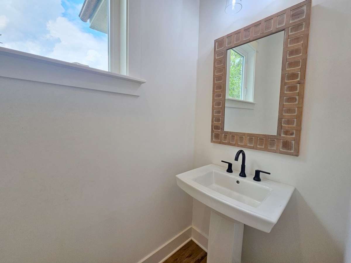 The half bath is located off the right side entry across from the laundry room and bonus room stairs.