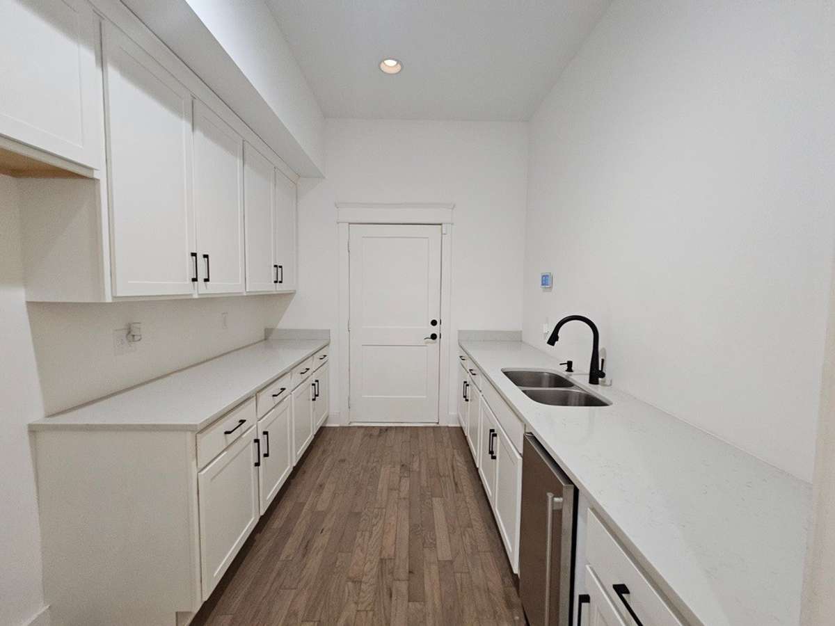 The Butler's pantry is located off the entertainment area with a double sink, ice maker and room for a full sized fridge with loads of cabinet space. The door ahead leads to the lower level garage accessible from the double garage doors in the front.