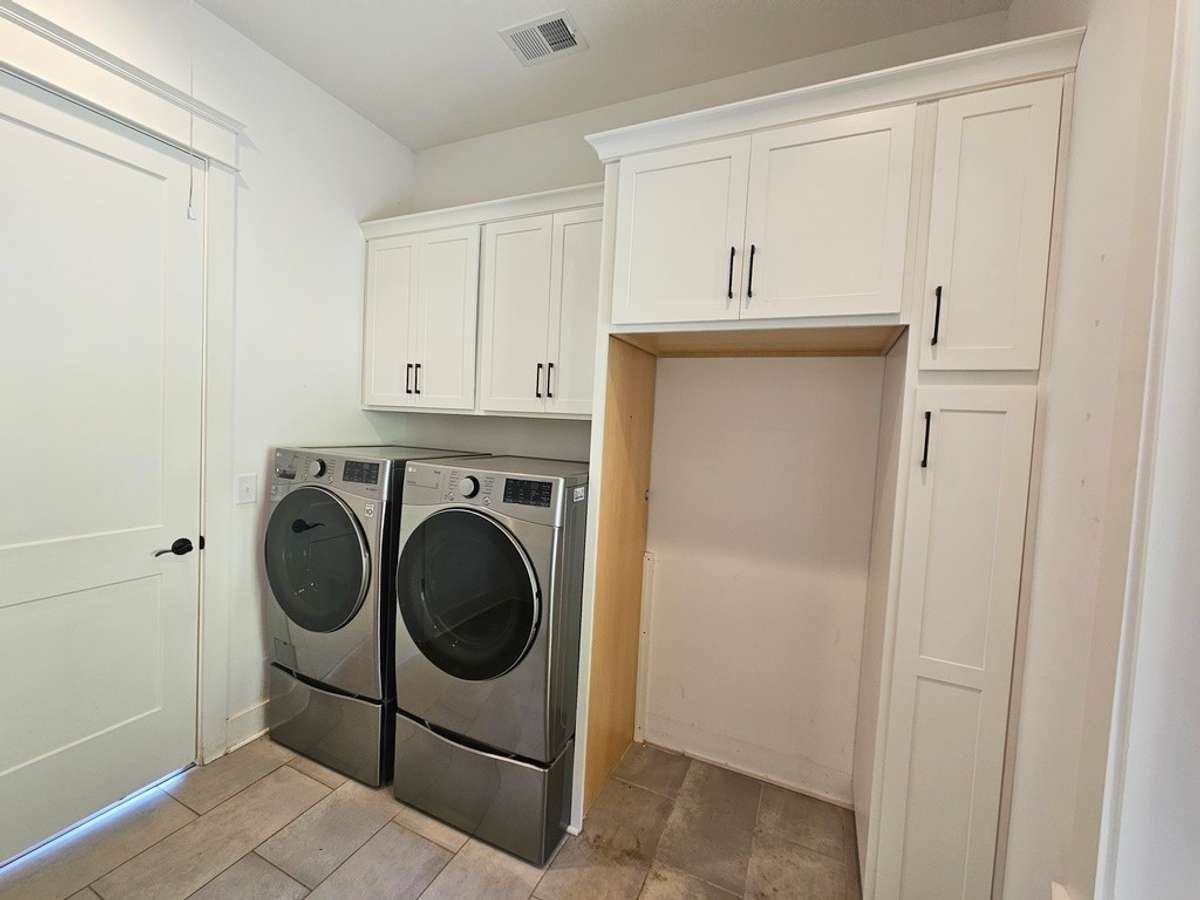 The laundry room is located off the hall behind the kitchen. Comes with stainless washer and dryer and a spot for a second refigerator or freezer.