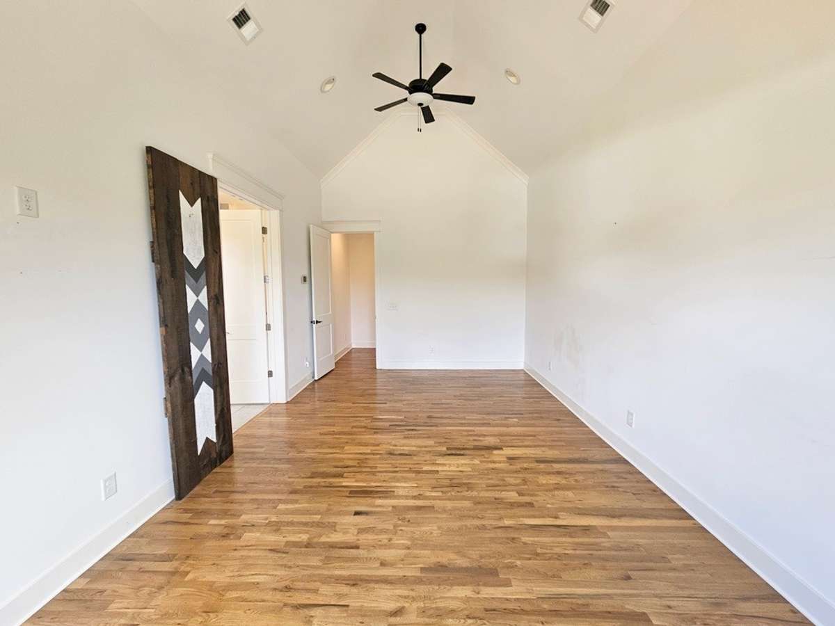 Primary bedroom suite located on the left side of the main level extending the width of the home.