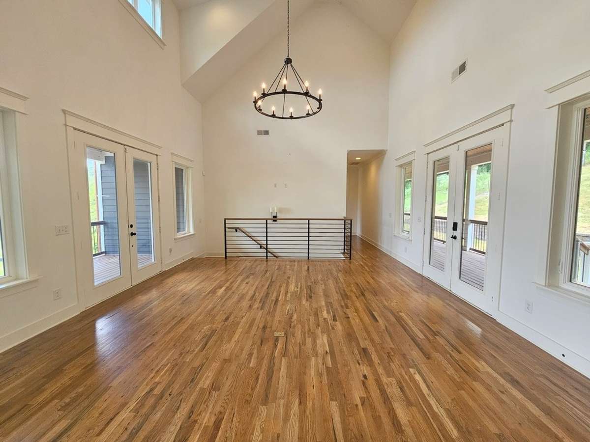 Spacious living room with a wall of windows on each side. This space is well lighted with a deck on the front to watch the sunrise and a deck on the back to watch the sunset.