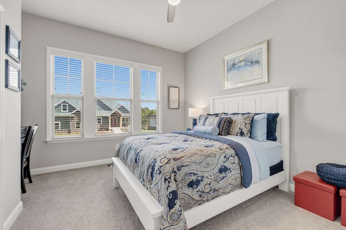 The secondary downstairs bedroom has plenty of space, light, closets and even a nook for a writing desk.