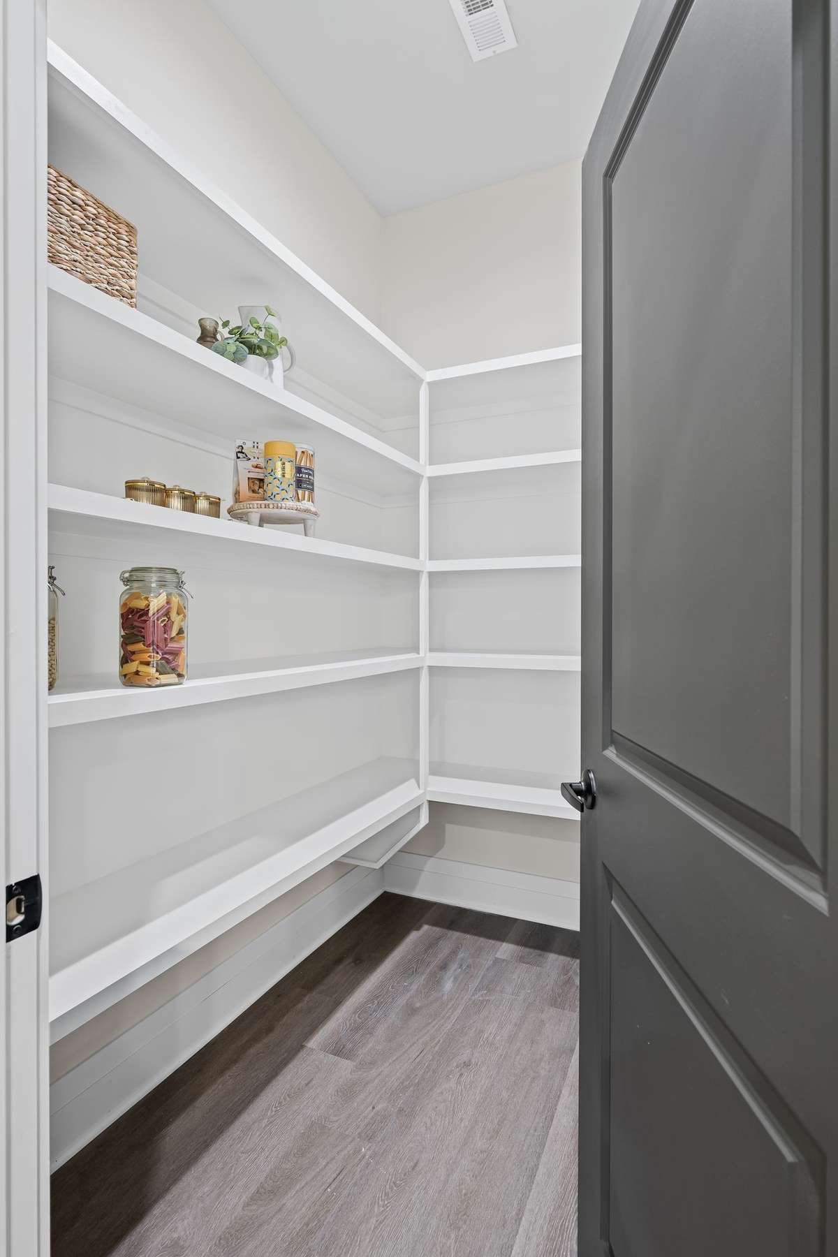 Spacious walk in pantry with custom cabinetry.