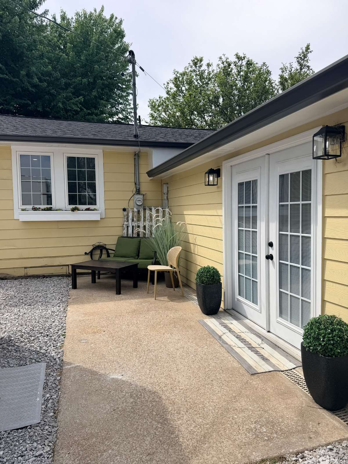 Entrance on driveway side of house. Patio area and large French doors.