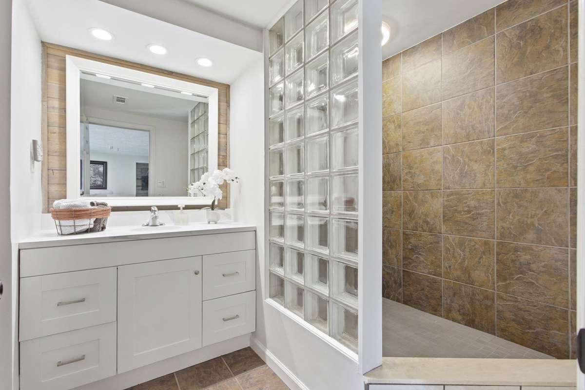 Bathroom with new vanity and glass block shower with new shower head.