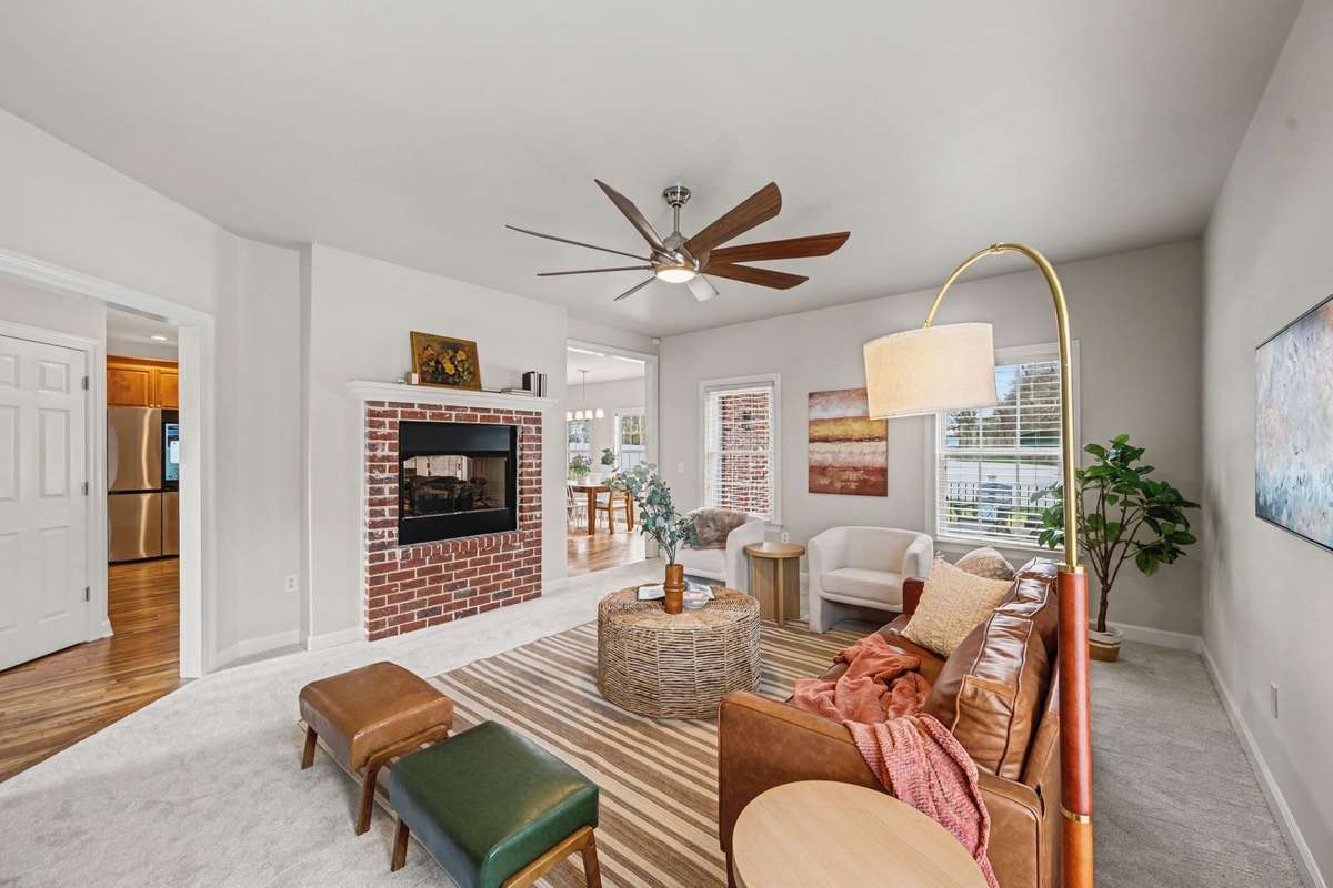 Spacious den / living area featuring new flooring, fresh paint, & a gas fireplace that creates a warm, inviting focal point. Seamlessly connected to the kitchen, this versatile space offers the perfect setting for everyday living, & entertaining