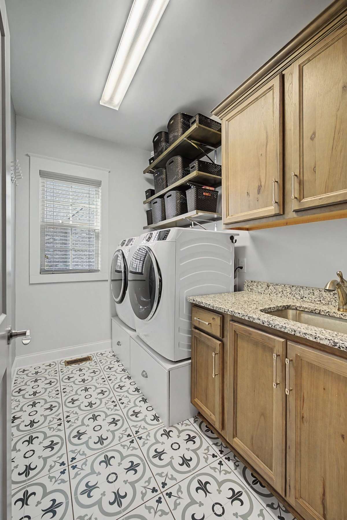 Large laundry room with beautiful tiled flooring and extra cabinetry.