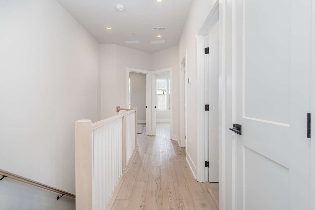 Second floor hall way with access to laundry room, hall bath and additional bedrooms.  *Photos are of a similar floorplan with differing finishes.*