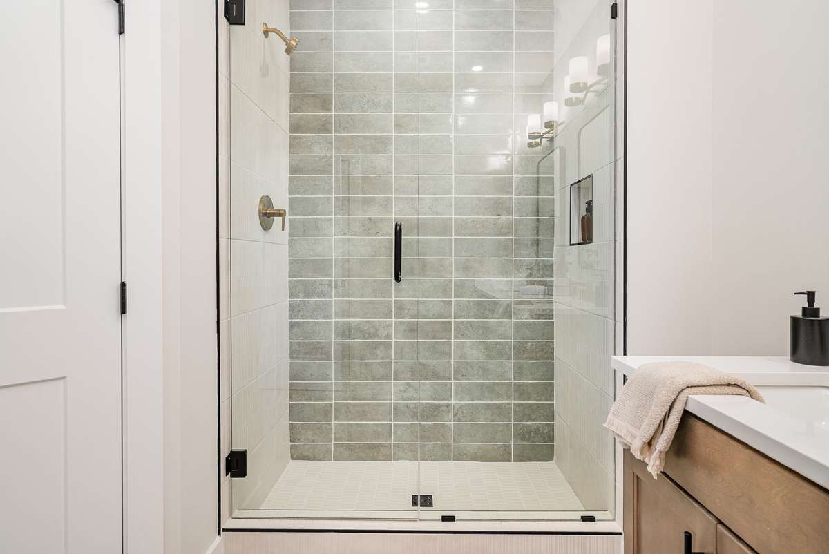 Stunning primary shower with floor to ceiling tiles.  *Photos are of a similar floorplan with differing finishes.*