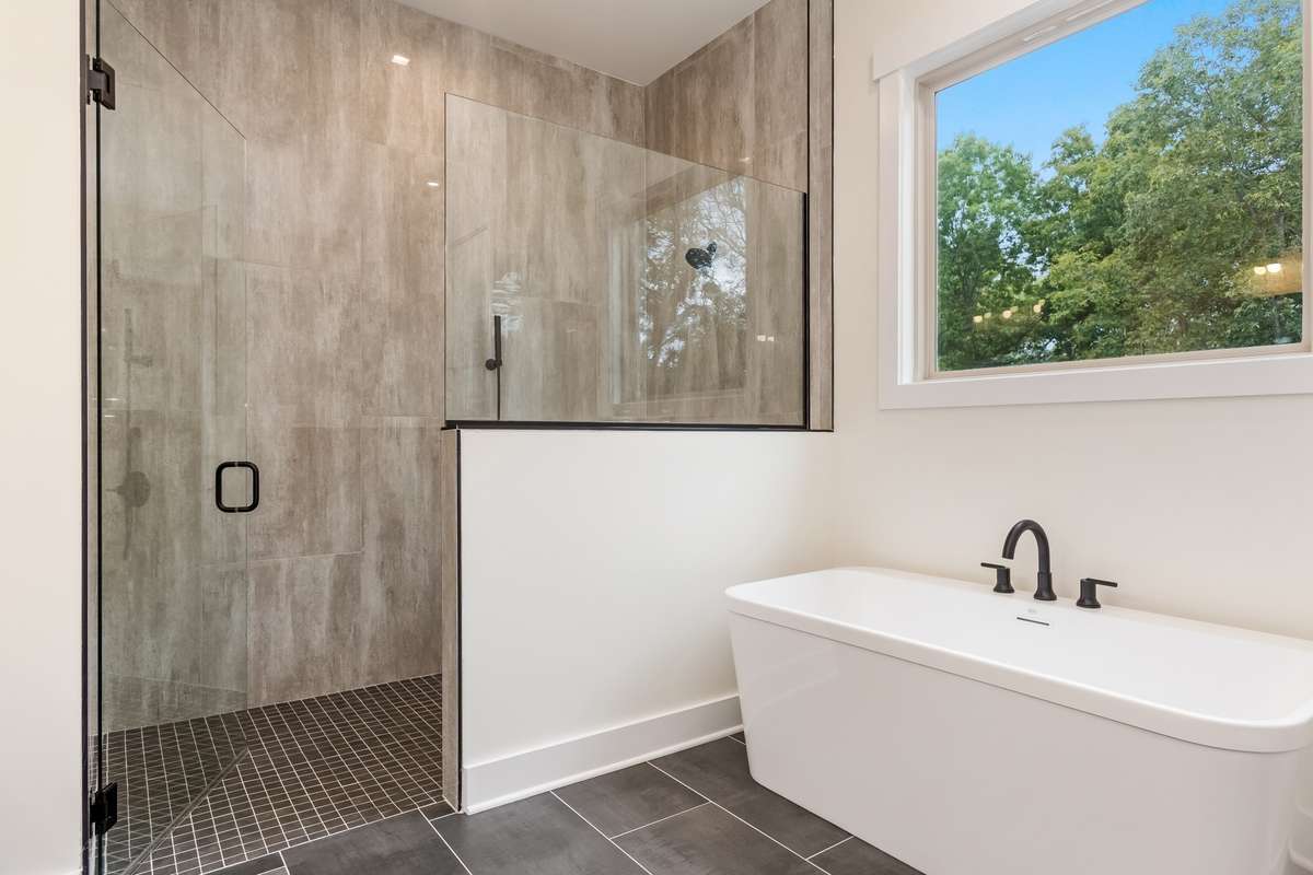 Large glass enclosed shower with two shower heads.