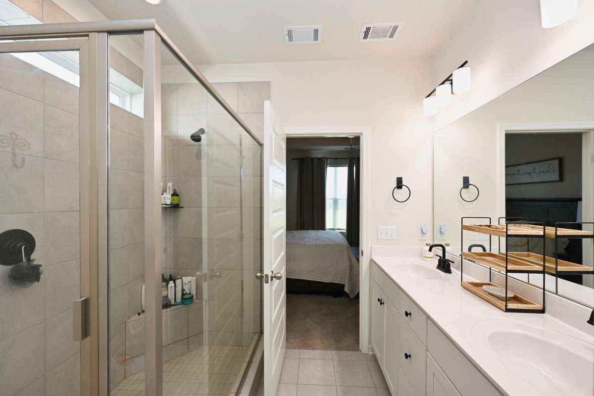 Master bath has tiled floor and oversized walk in shower and double vanities.