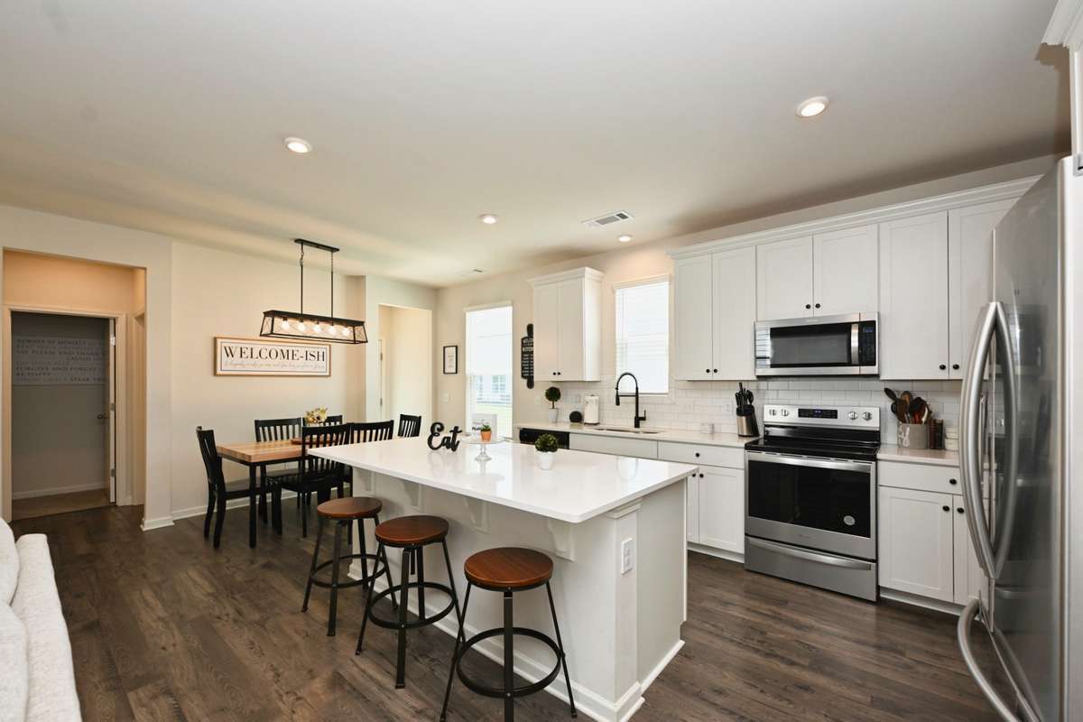 Stainless appliances with dining area.