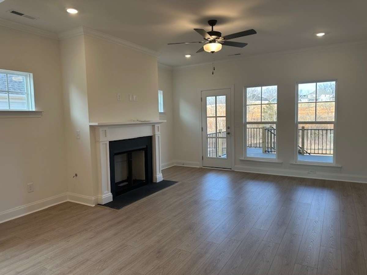 Cozy up to your gas fireplace here in the Great Room! Ample lighting, gorgeous flooring, crown moulding, and access to the covered deck create an inviting space!